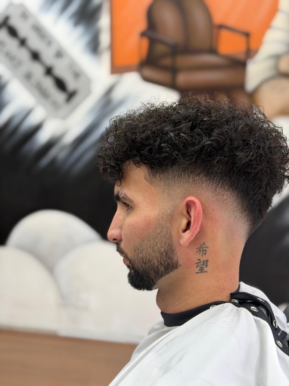 Corte cacheado com degradê na lateral